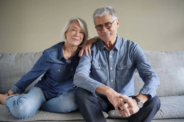 Modern Senior Couple Denim Couch Looking Camera — Stock Photo, Image