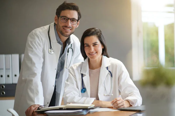 Young doctors in lab coats smiling