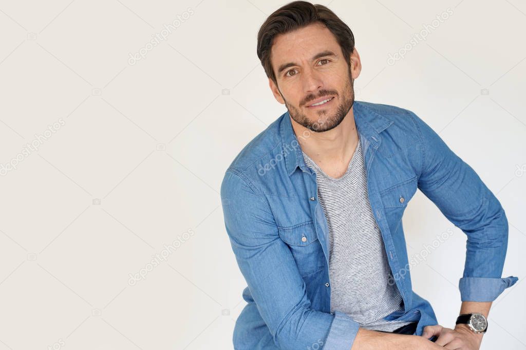 Very handsome casual man sitting on white background
