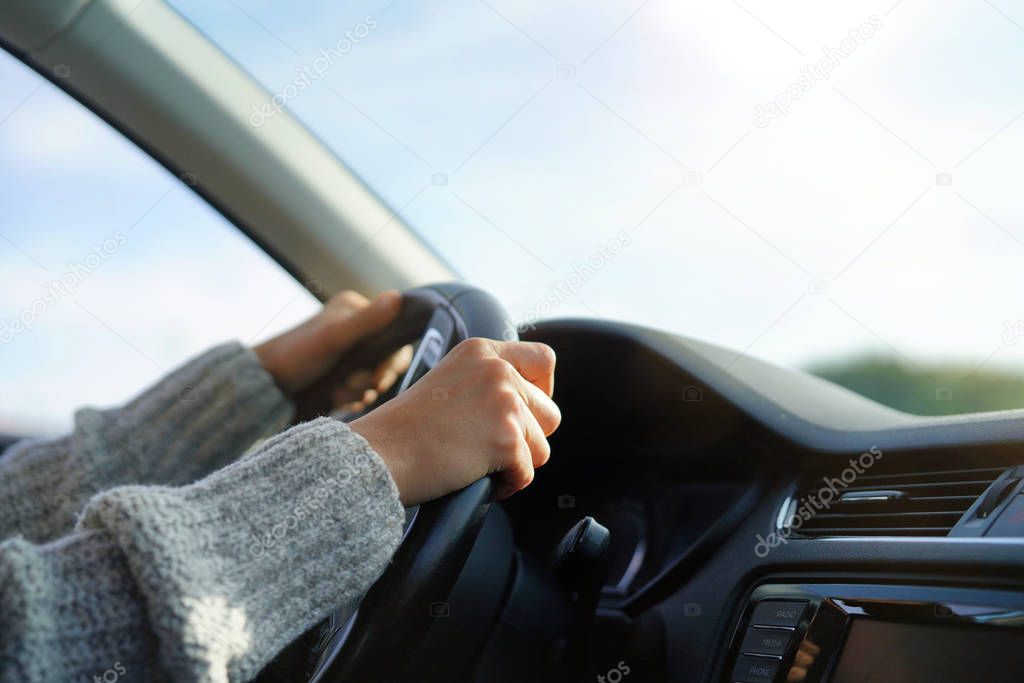 Close up of woman's hands on steering wheel