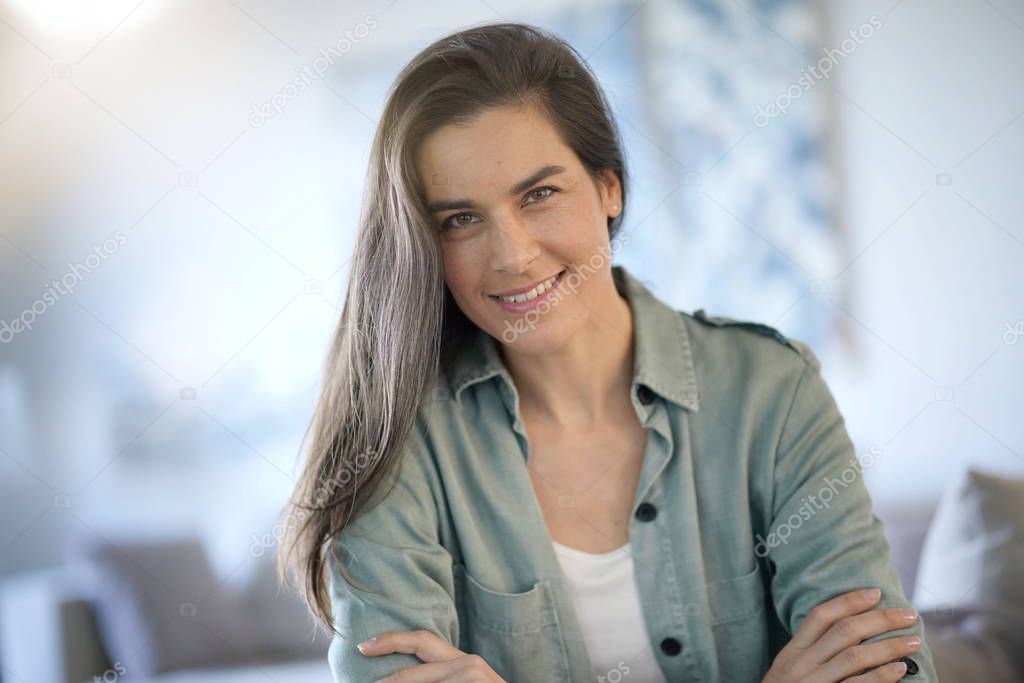  Portrait of stunning brunette smiling indoors                              