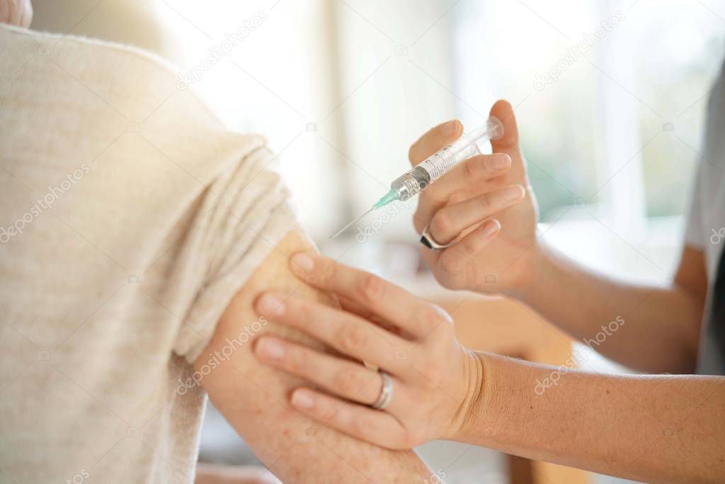 Close up of senior woman geting flu shot                              