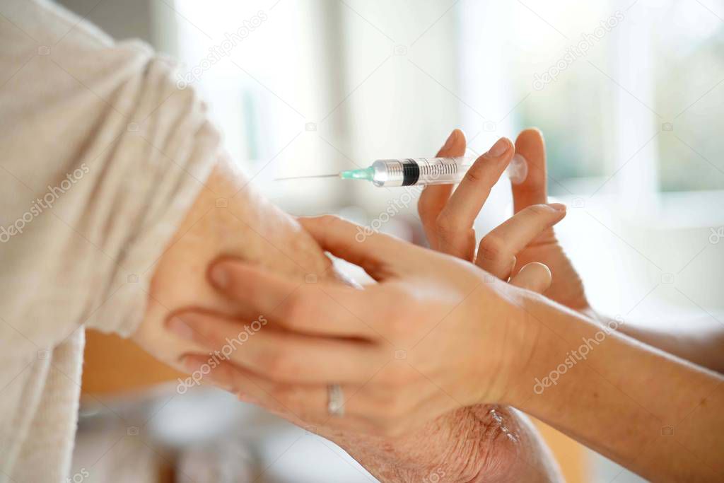 Close up of senior woman geting flu shot                              