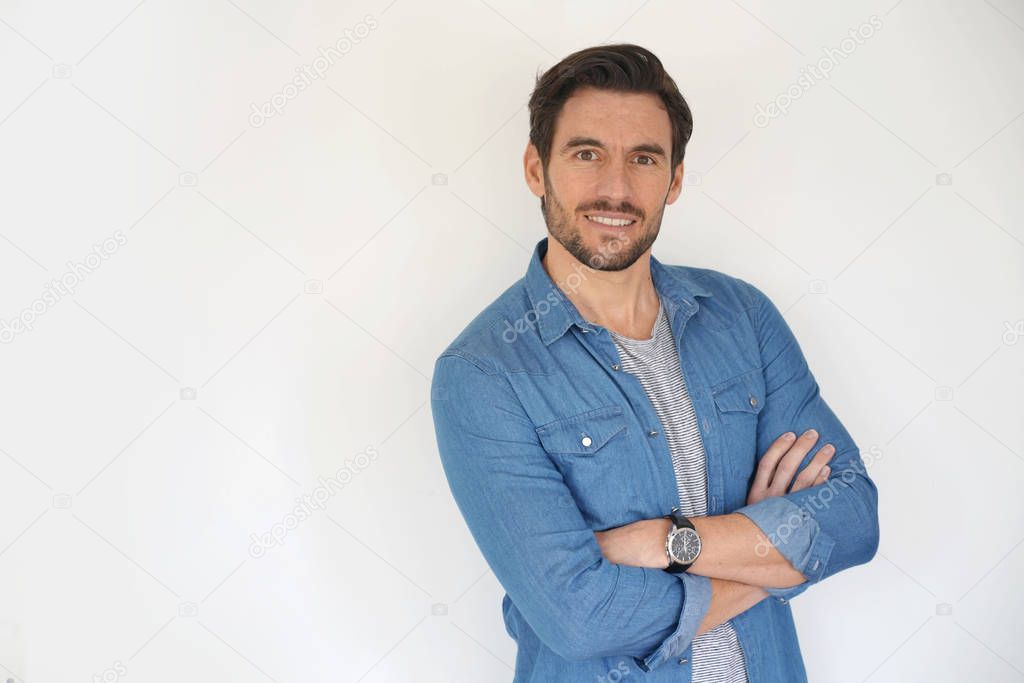 Very handsome casual man smiling and standing on white background