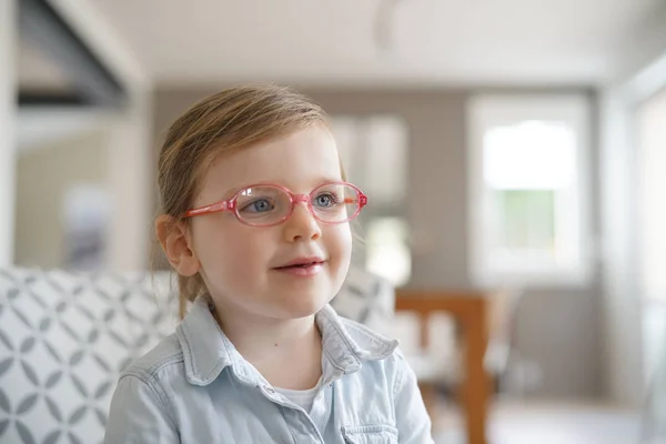 可爱的年轻女孩的肖像与蓝眼睛戴眼镜在家里 — 图库照片