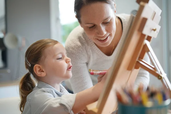 母亲教小女儿在家里画画架 — 图库照片