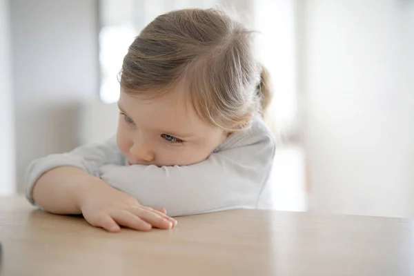 Porträtt Bedårande Flicka Inomhus Med Armarna Korsade Bord — Stockfoto