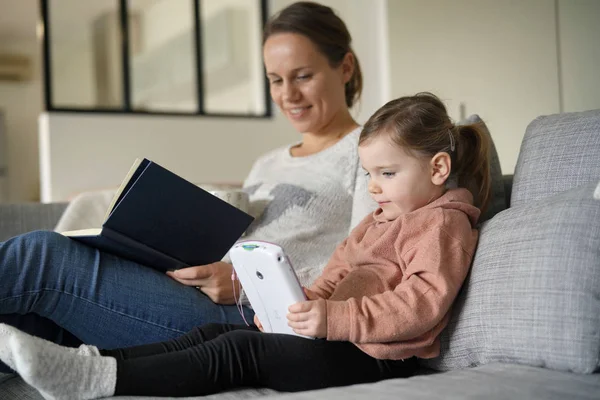 Ibu Dan Anak Kecil Membaca Dan Bermain Tablet Rumah — Stok Foto