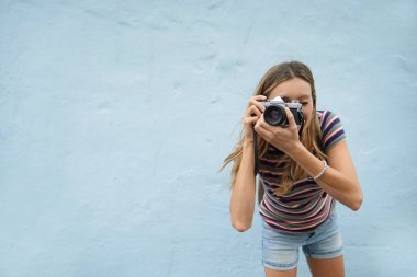 Dinamik fotoğraf öğrenci mavi arka plan üzerinde kamera karşı karşıya