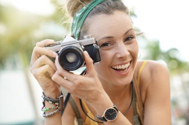 Kentsel ortamda vintage fotoğraf makinesi ile fotoğraf çekmek şık genç kadın portresi