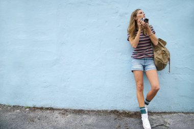 Çekici backpacker ile mavi arka plan üzerine açık havada vintage fotoğraf makinesi