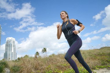 Beachy peyzaj çalıştıran atletik genç kadın