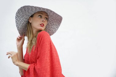 Kırmızı elbise ve şapka beyaz arka plan üzerinde poz çekici sarışın