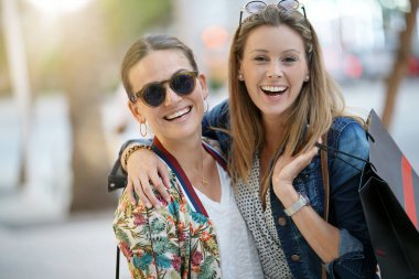 Şehirde alışveriş çılgınlığı arkadaşlar gülümseyen