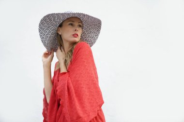 Kırmızı elbise ve şapka beyaz arka plan üzerinde poz çekici sarışın