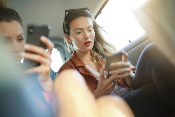 Twee Aantrekkelijke Vrienden Texting Achterkant Taxi Casual Avondkleding — Stockfoto