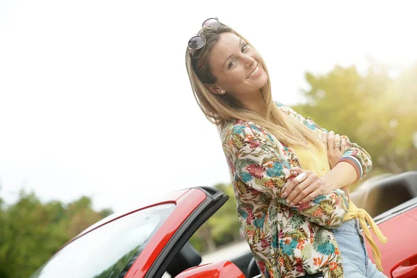 Ελκυστική Νεαρή Γυναίκα Που Ακουμπά Στο Κόκκινο Μετατρέψιμο Αυτοκίνητο — Φωτογραφία Αρχείου