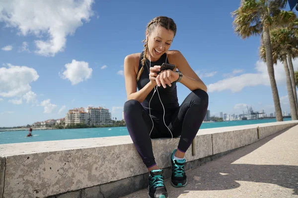 Mujer Deportiva Sonriente Comprobando Teléfono Celular Sol Aire Libre — Foto de Stock