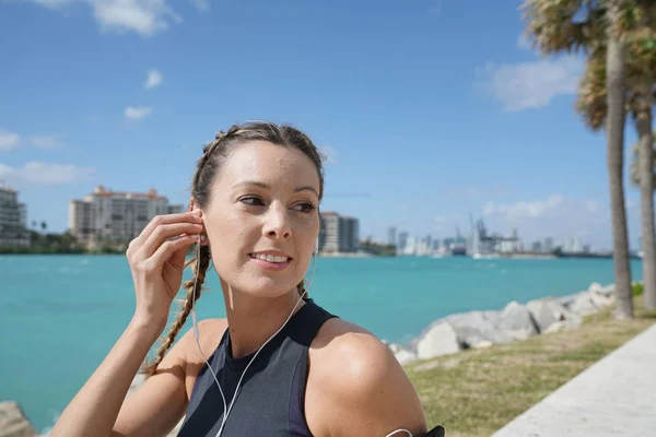 年轻的运动的妇女在跑了以后在太阳休息了出来 免版税图库照片