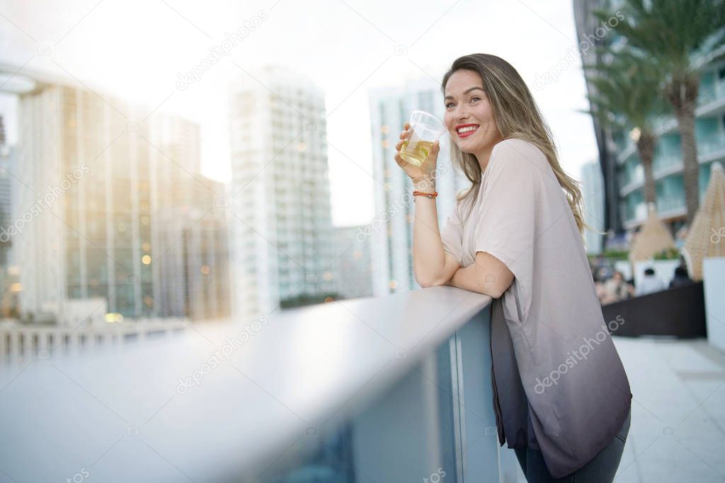 Atttractive elegant young woman having fun smiling on rooftop bar in city