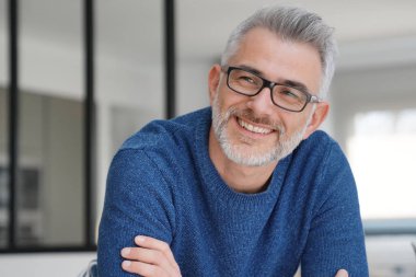 Gri saçlı ve gözlüklü adamla gülümseyen portresi