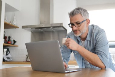 Adam evde modern mutfak bilgisayar ile