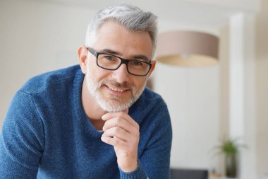Gri saçlı ve gözlüklü adamla gülümseyen portresi