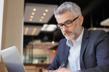 Modern havaalanında bekleyen bilgisayar ile çalışma Businessmn