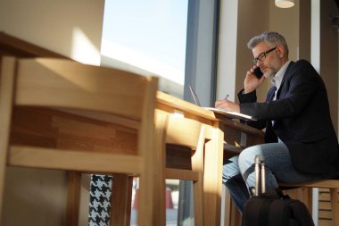 Havaalanı toplantıda prepping cep telefonu konuşurken işadamı