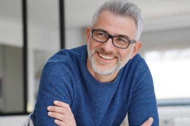 Gri saçlı ve gözlüklü adamla gülümseyen portresi