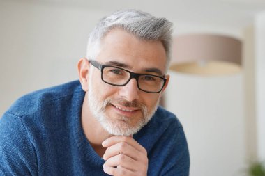 Gri saçlı ve gözlüklü adamla gülümseyen portresi