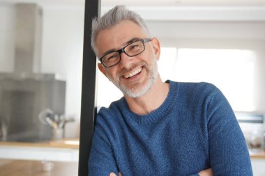 Eğilerek ve modern mutfak ev gülümseyen adam