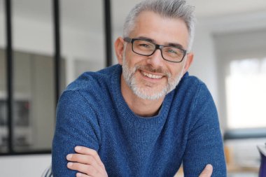 Gri saçlı ve gözlüklü adamla gülümseyen portresi