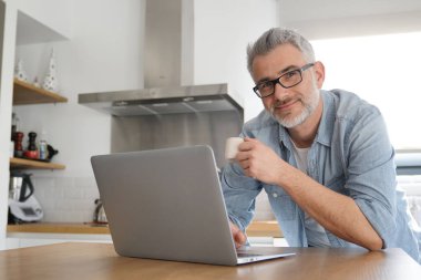 Adam evde modern mutfak bilgisayar ile