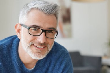 Gri saçlı ve gözlüklü adamla gülümseyen portresi