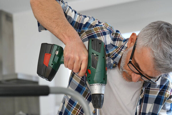 Зрелый человек, использующий силовые упражнения дома
