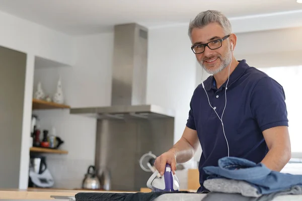 Hombre Mirando Cámara Planchando Ropa Cocina Moderna — Foto de Stock