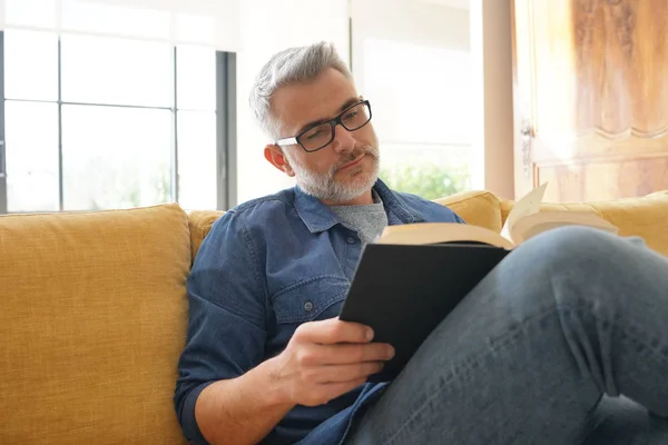 Hombre Años Leyendo Libro Casa Moderna —  Fotos de Stock