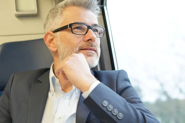 Geschäftsmann Sitzt Zug Und Schaut Durchs Fenster — Stockfoto