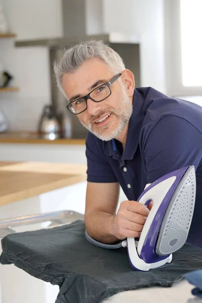 Volwassen Man Leunend Strijkplank Ijzer Bedrijf Moderne Keuken — Stockfoto