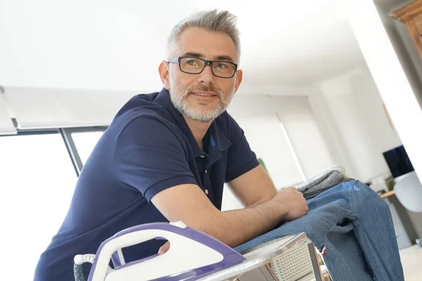 Älterer Mann Stützt Sich Hause Auf Bügelbrett Mit Wäsche — Stockfoto