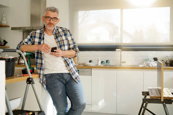 Volwassen Klusjesman Kijken Camera Leunend Ladder Moderne Keuken — Stockfoto