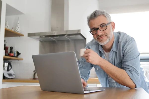 Man Met Computer Thuis Moderne Keuken Stockfoto