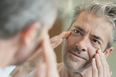 Evde aynaya bakan olgun yakışıklı adam Portresi