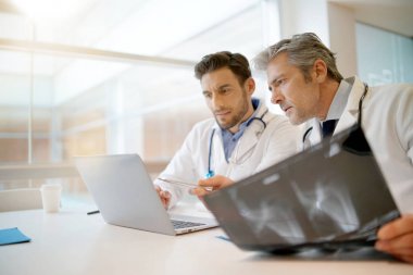 Doktorlar hastanede hastanın sonuçları üzerinden gidiyor