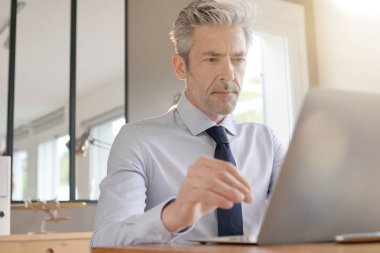 Çağdaş ofiste çalışan yakışıklı işadamı