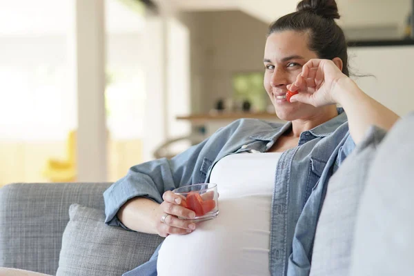 自宅でくつろぎ イチゴを食べる妊婦 — ストック写真