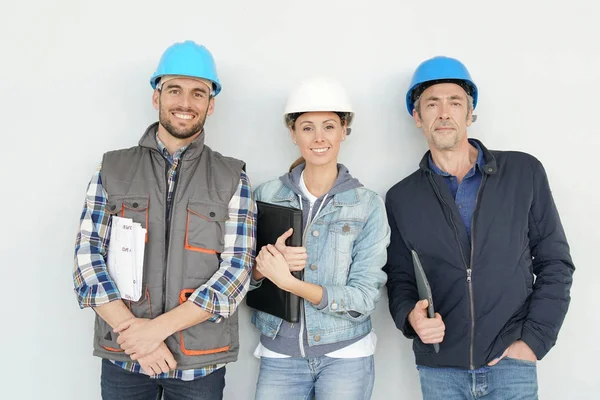 Gemischtes Bauteam Lächelt Vor Grauem Hintergrund Die Kamera — Stockfoto