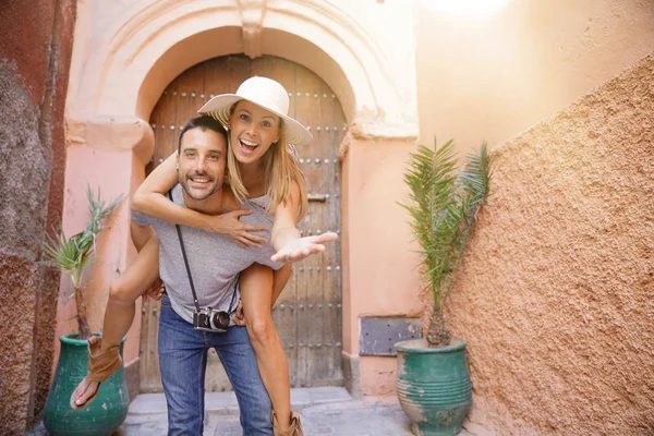 Marakeş sokakta kız arkadaşı için piggyback binmek veren adam