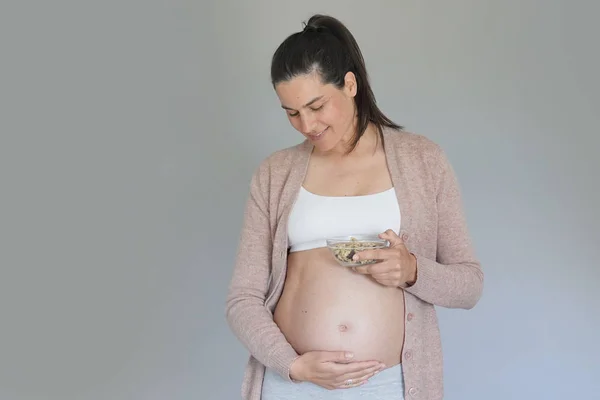 Pregnant woman eating cereals, isolated